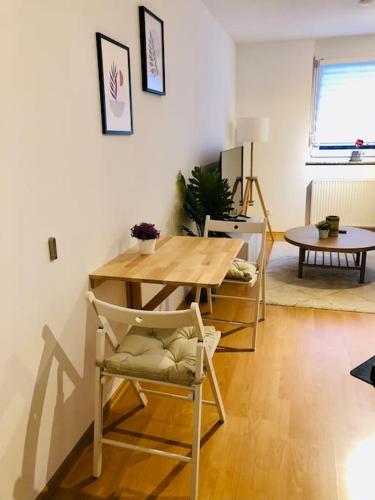 a living room with a table and a table and chairs at Modernes Apartment mit Küche, Parkplatz, WLAN - Nähe Schwäbisch Gmünd in Waldstetten