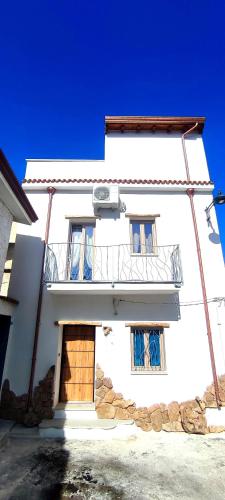 a white building with a door and a balcony at Sa Terra Mea - Luxury Apartment in Torpè