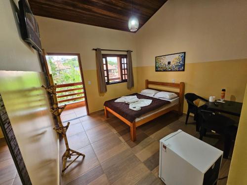 a bedroom with a bed and a desk in a room at Pousada Recanto Passarela in Aparecida