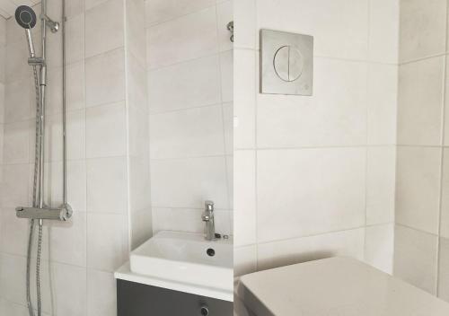 uma casa de banho branca com um chuveiro e um WC. em Modern&Quiet 7th floor Apt with Balcony, Free 5G WIFI, Laukontori em Tampere