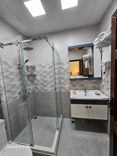 a bathroom with a shower and a sink at Hotel Sharq in Dushanbe