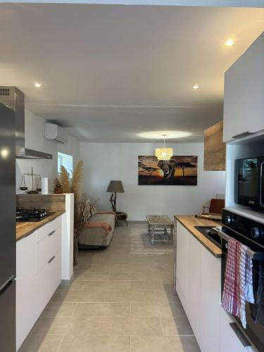 eine Küche mit weißen Schränken und ein Wohnzimmer in der Unterkunft Maison individuelle entierement rénovée in Porto-Vecchio