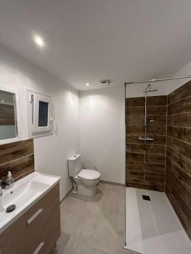 a bathroom with a toilet and a glass shower at Maison individuelle entierement rénovée in Porto-Vecchio
