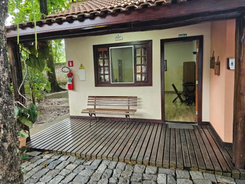 a bench sitting on a porch of a house at Pousada Recanto Passarela in Aparecida