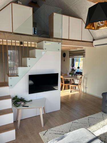 a kitchen and living room with white cabinets at Bear House in Sigulda