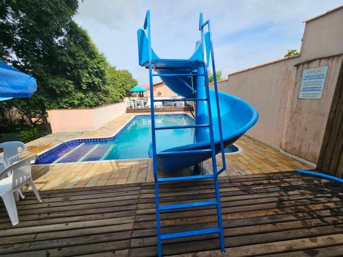 a blue slide next to a swimming pool at Pousada Recanto Passarela in Aparecida