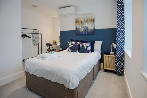 a bedroom with a large bed with blue and white walls at 1 Bedroom Apartment Urban Stay in Peterborough