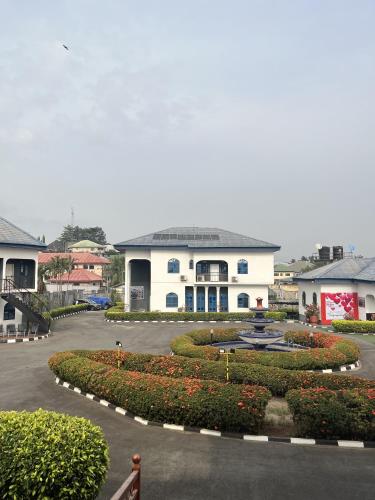 a large white building with a courtyard with flowers at Teny Homes in Calabar