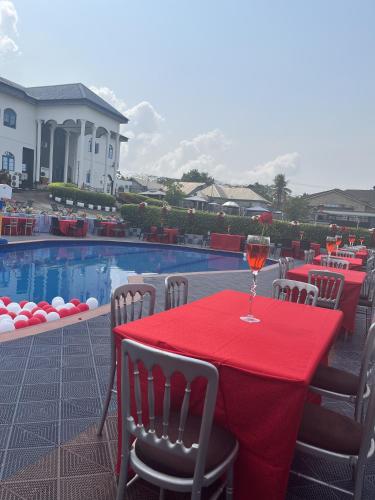 a red table with a glass of wine on a patio at Teny Homes in Calabar