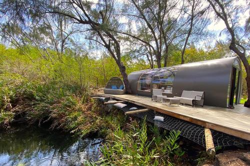 a train on a wooden platform next to a river at Bubble Lodge Ile aux Cerfs Island in Ile aux Cerfs