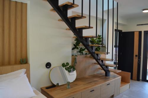 a bedroom with a wooden staircase with a mirror at Rastoni RQD 6 in Arkoudi
