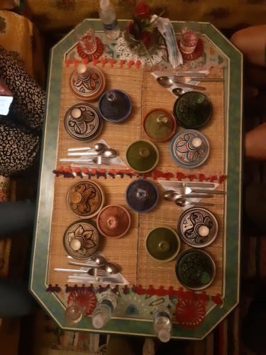 a table topped withcolored plates and spoons at Dar Pa Labzioui in Meknès