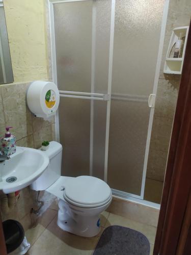 a bathroom with a shower and a toilet and a sink at LODGE NATAN in Quito