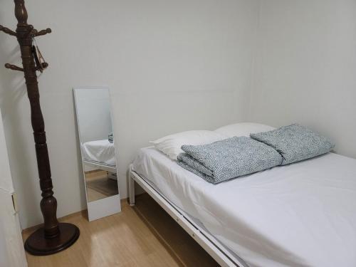 BlueBird Guesthouse - Foreign Only في سول: غرفة نوم بسرير ومرآة بجانبها