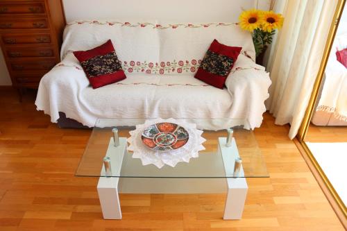 sala de estar con sofá y mesa de cristal en Magnifico apartamento con vistas al mar, en Alicante