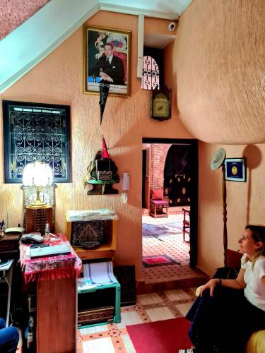 a woman sitting on a couch in a living room at Dar Pa Labzioui in Meknès