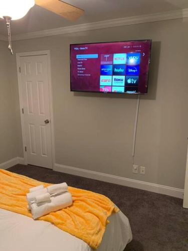 a bedroom with a flat screen tv on the wall at Good Vibe in the heart of Plaza/Midwood area in Charlotte