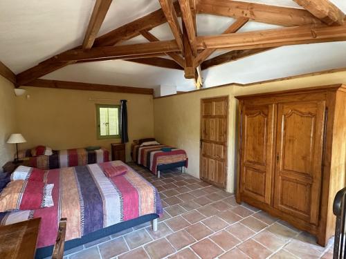 1 Schlafzimmer mit 2 Betten in einem Zimmer mit Holzdecken in der Unterkunft Mas des sauges in Saint-Mathieu-de-Tréviers