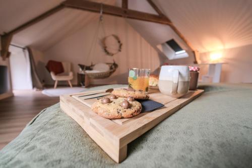 - 2 biscuits sur un plateau en bois sur un lit dans l'établissement Maison Eliste - Love gîte chic avec jacuzzi intérieur, à La Gacilly