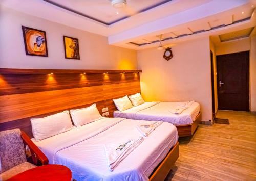 a hotel room with two beds and a chair at HOTEL SEBAA PALACE in Kanyakumari