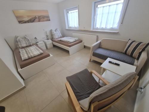 einen Blick über ein Wohnzimmer mit Sofa und Stühlen in der Unterkunft Schöne helle Wohnung in Malsch in Malsch