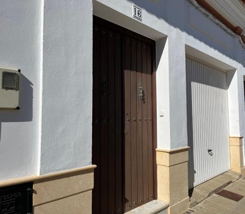 una puerta marrón en el lateral de un edificio en Pino Grande 16, en El Viso del Alcor