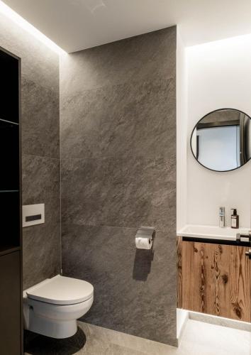 a bathroom with a toilet and a mirror at Hollywood Dream Penthouse & Apartments mit privater Sauna nahe Ischgl in Kappl