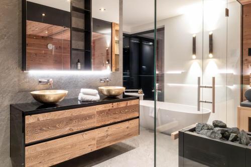 a bathroom with two sinks and a tub at Hollywood Dream Penthouse & Apartments mit privater Sauna nahe Ischgl in Kappl