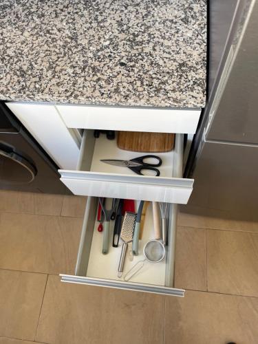 a kitchen drawer with scissors and other kitchen utensils at Piso nuevo muy cerca de la playa in Santa Pola