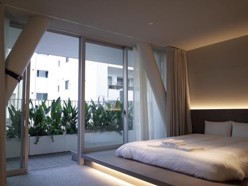 een slaapkamer met een bed en een groot raam bij Hotel Rakuragu in Tokyo