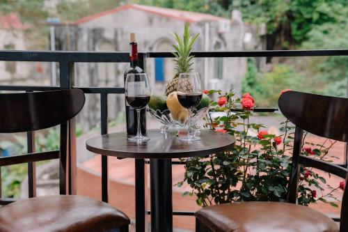 einen Tisch mit einer Flasche Wein und zwei Gläsern in der Unterkunft Napoli Hostel in Cát Bà