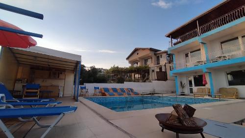 a swimming pool with blue chairs and a building at Antorino in Balchik