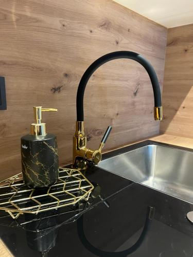 a kitchen sink with a faucet on a counter at Apartamentai JOLA in Vilkaviškis