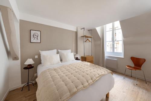 une chambre avec un grand lit et une fenêtre dans l'établissement Appartement luxueux au cœur de Saint Germain des Prés, à Paris