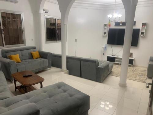 sala de estar con sofá y TV en La belle étape, en Dakar