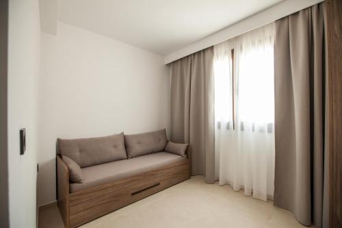 a couch in a room with a window at Verano Afytos Hotel in Afitos