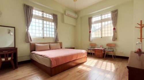 een slaapkamer met een bed en 2 ramen en een spiegel bij Dilly Dally B&B in Gukeng