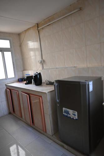 a small kitchen with a counter and a refrigerator at Stylish Hilltop King Bed Apartment with Free Parking and Wifi in Wuţayyah