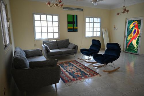 a living room with couches and chairs and a rug at Stylish Hilltop King Bed Apartment with Free Parking and Wifi in Wuţayyah