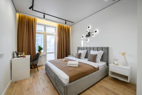 um quarto com uma cama grande e uma secretária em Пять НОВЫХ апартаментов БИЗНЕС КЛАССА в ЖК R-HOUSE в 100 м от MEGA em Almaty