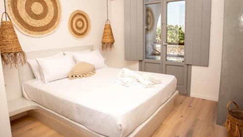 un letto bianco in una stanza con finestra di Aidani Luxurious Rooms a Vóthon