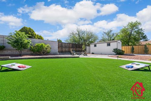un césped con dos mesas de ping pong en un patio en Casa De Paradise Hills, en Albuquerque