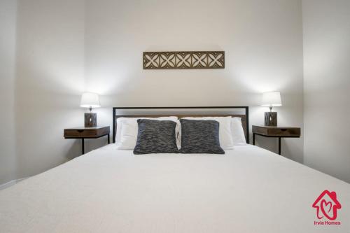 a bedroom with a white bed with two night stands at Petroglyph Place - An Irvie Home in Albuquerque