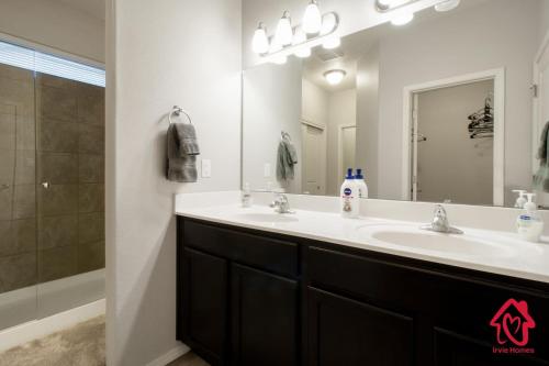 baño con 2 lavabos y espejo grande en Petroglyph Place - An Irvie Home, en Albuquerque