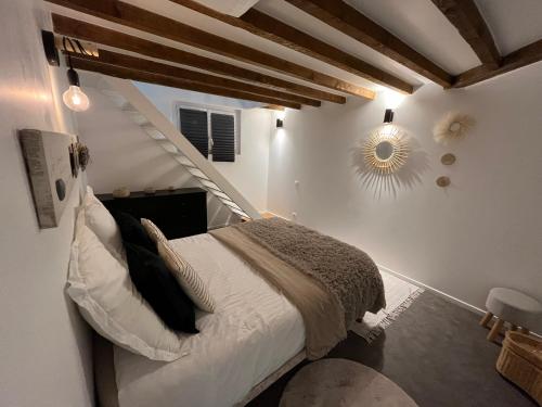 - une chambre avec un lit dans une pièce avec des escaliers dans l'établissement Charmante maison de ville, à Arnouville-lès-Gonesse