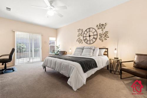 um quarto com uma cama grande e um relógio na parede em Pleasant View - An Irvie Home em Albuquerque