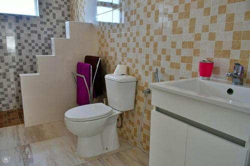 a bathroom with a white toilet and a sink at TARRAFAL SN TOUR in Tarrafal