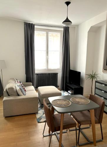 un salon avec une table et un canapé dans l'établissement Marais Modern & Spacious Studio, à Paris