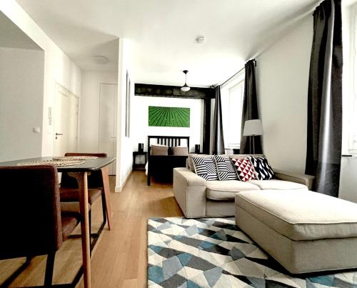 un salon avec un canapé et une table dans l'établissement Marais Modern & Spacious Studio, à Paris