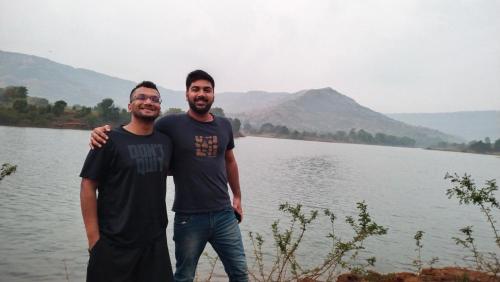 two men standing next to a body of water at The Wai Hills MTDC Approved in Wai